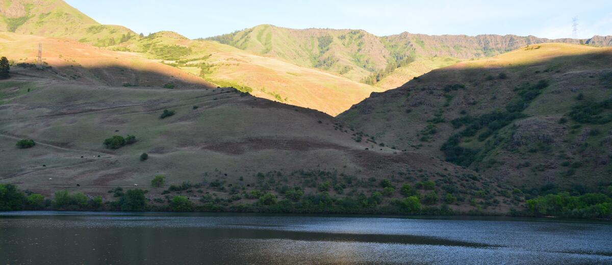 Golden light on ridges across still water